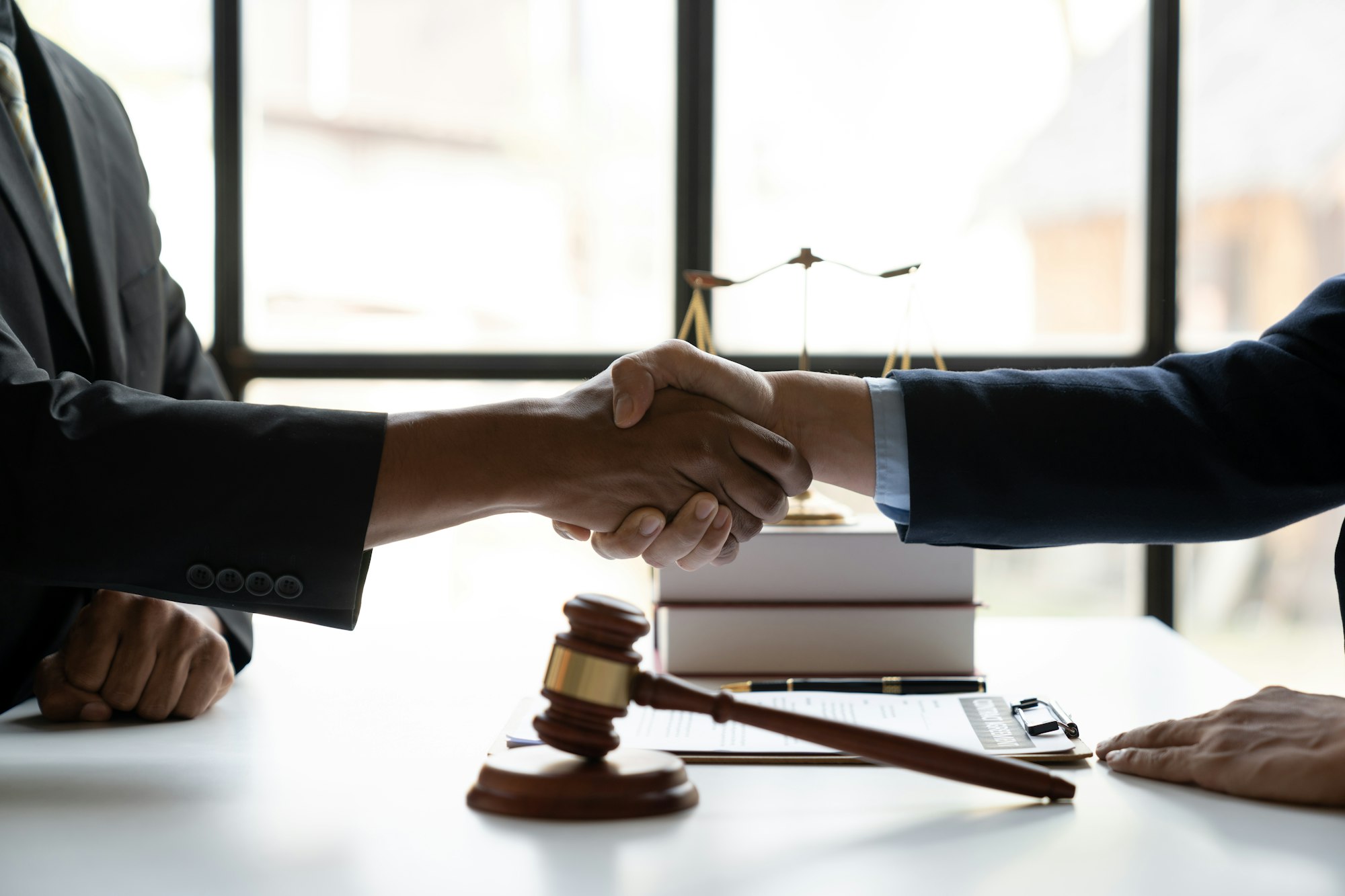 Legal and justice concept Young asian businessman shaking hands with young lawyer or legal advisor a